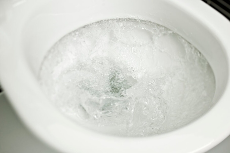 Close up of a toilet bowl being flushed